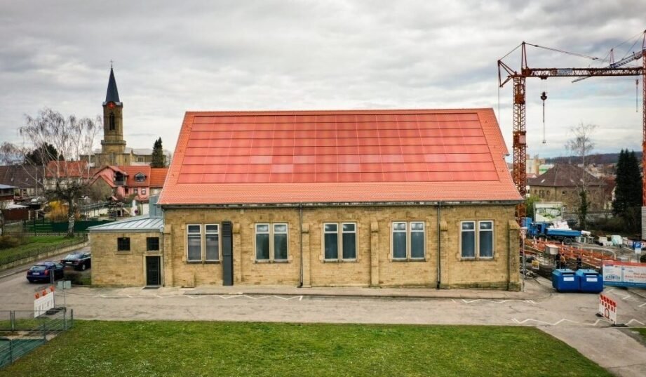 Zabytkowy budynek wyposażony w kolorowy dach fotowoltaiczny